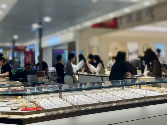 年轻消费者在北京某珠宝城挑选黄金首饰