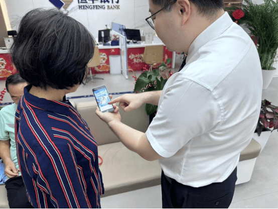 方庄支行客户经理正在为退休教室李阿姨介绍数字信用卡和“丰玩计划”超市立减活动