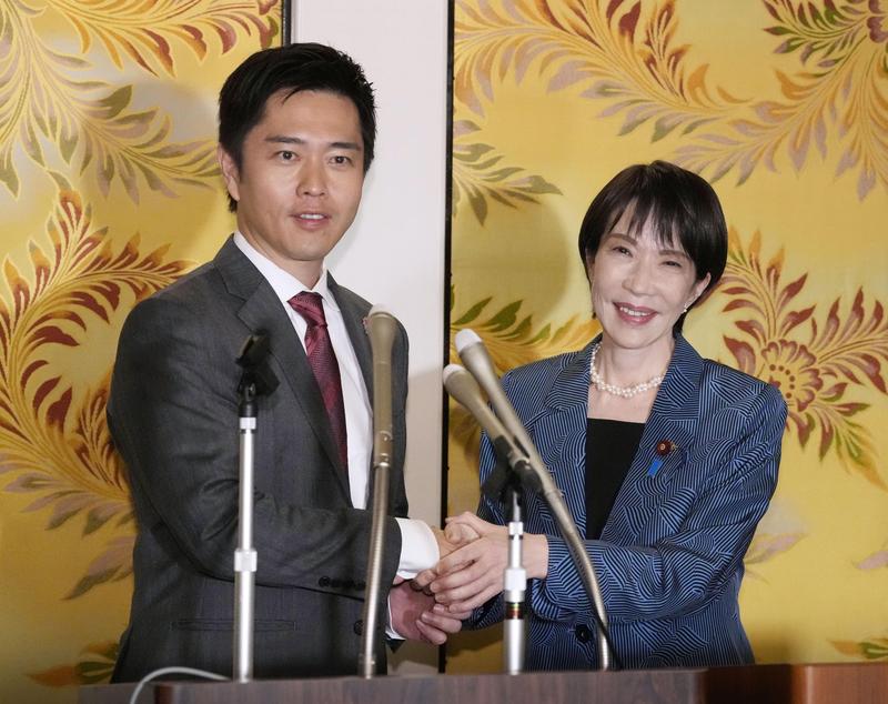 10月20日，在位于日本东京的日本国会，日本自民党总裁高市早苗（右）与维新会党首吉村洋文在记者会上握手。新华社