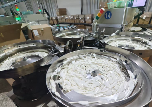 图为宇翔公司厂房内不同羽毛球片的智能分拣。邹臻杰/摄