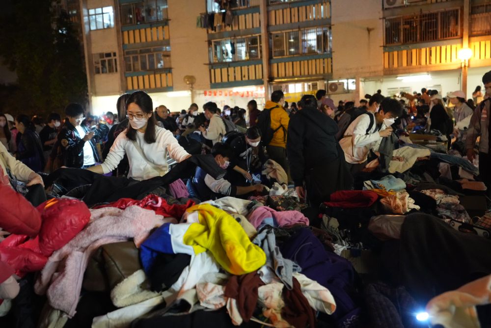 11月27日，义工在宏福苑附近向受火灾影响的市民派发物资。新华社发（吕小炜摄）