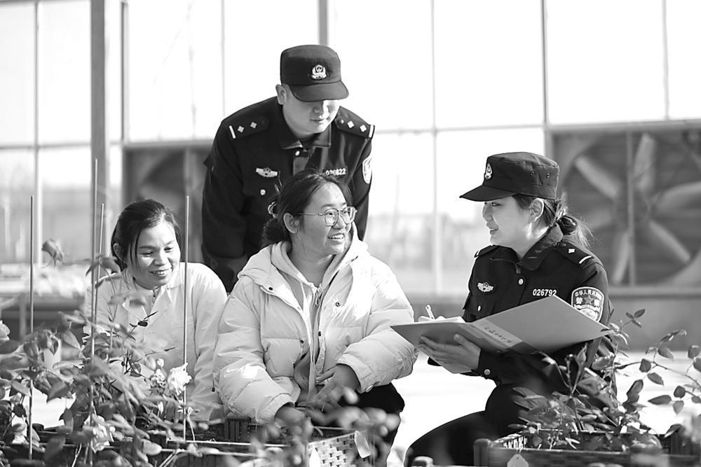 图为民警向企业员工进行普法宣传。