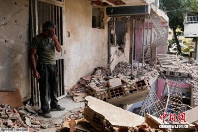 图为当地时间1月4日，在委内瑞拉卡蒂亚拉马尔，当地居民站在遭美军空袭后的家中。