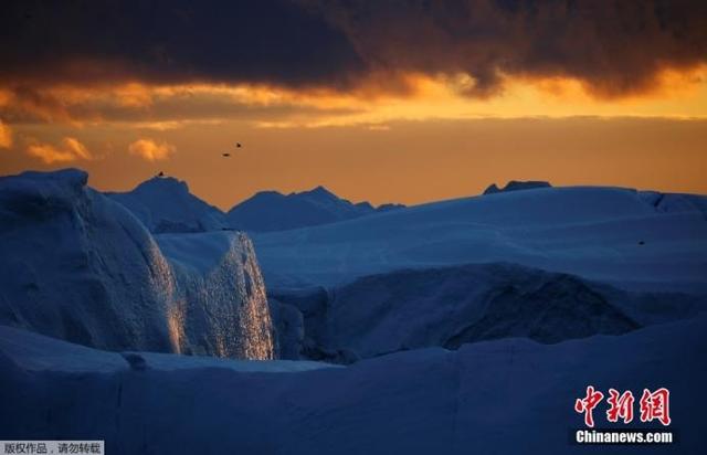 资料图：格陵兰岛伊卢利萨特附近的迪斯科湾，日落时，阳光反射在冰山上。
